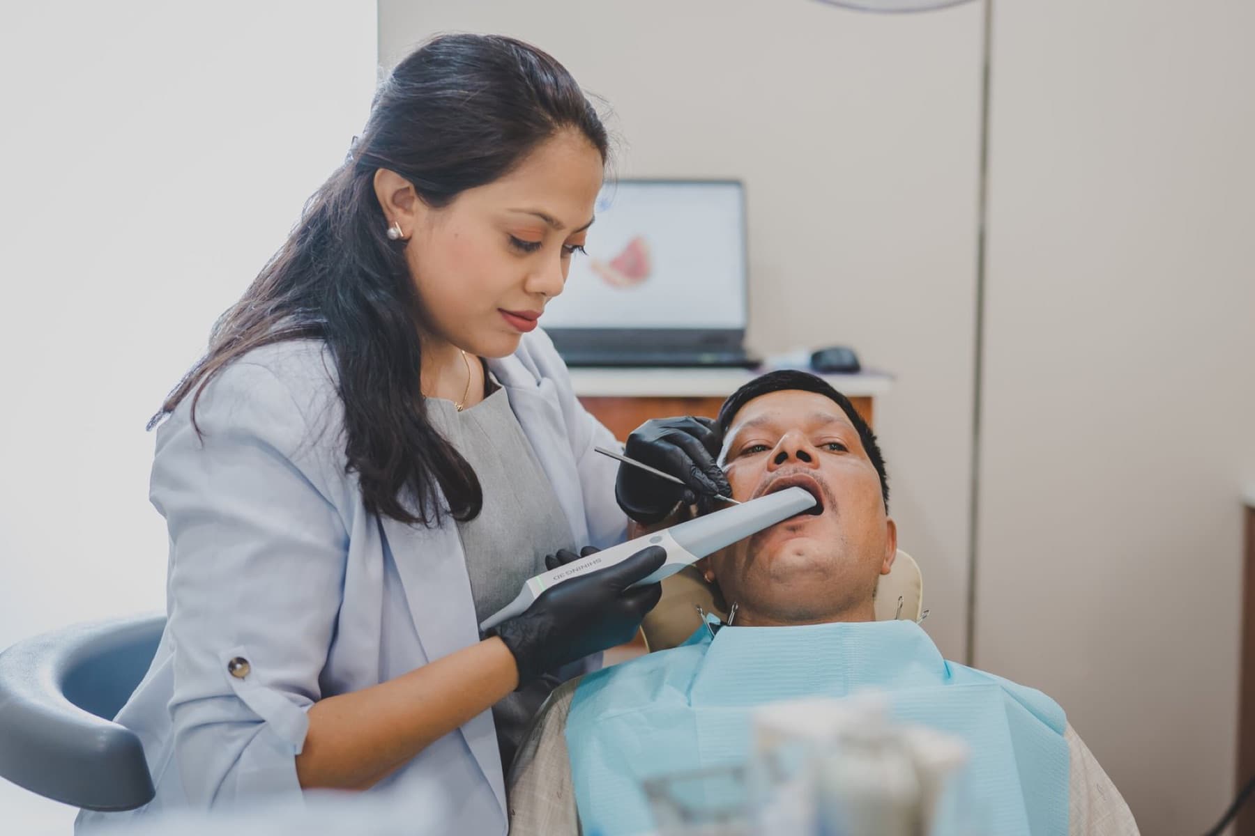 A dentist taking a digital intraoral scan for a crown