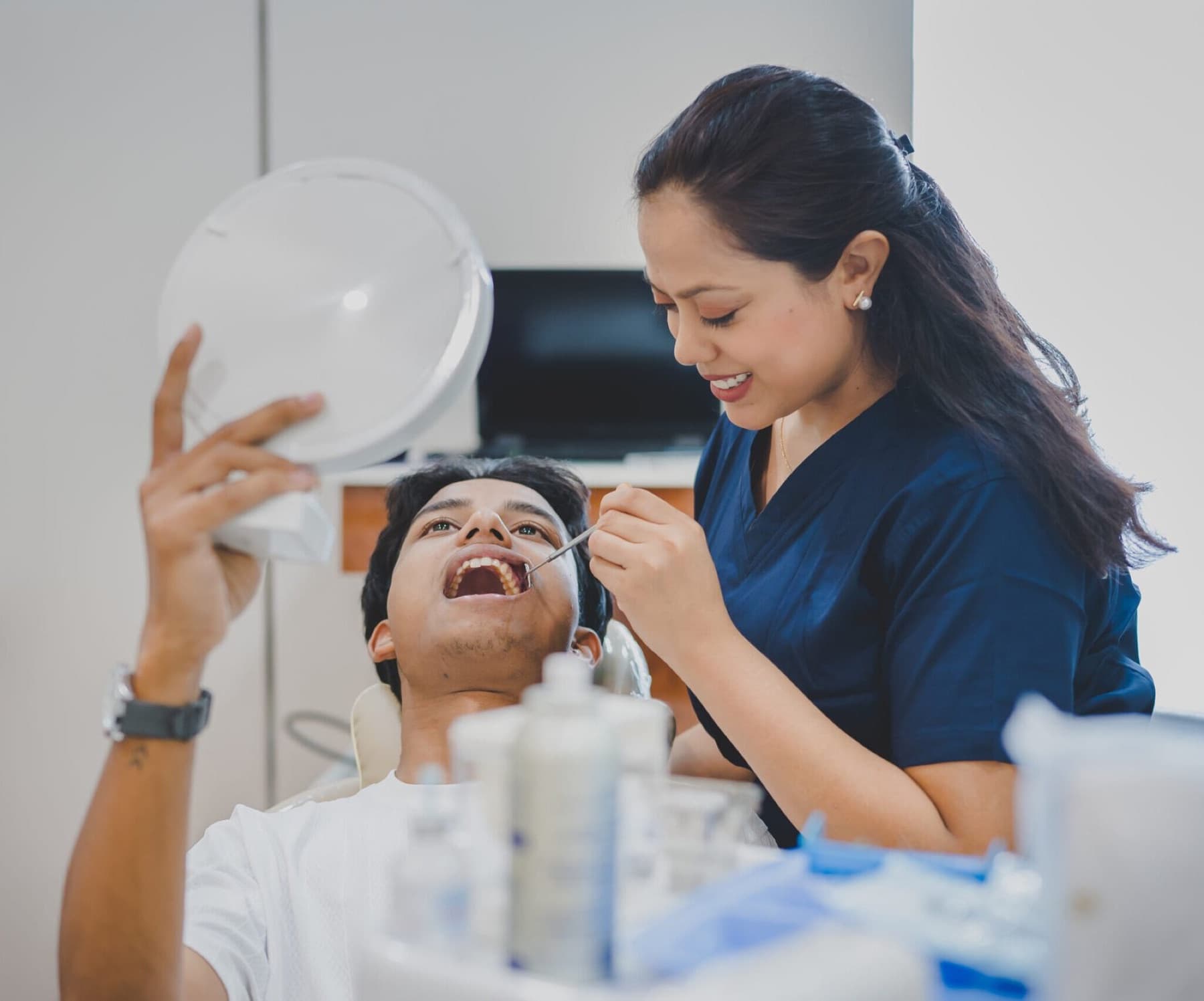 A patient checking their smile in a mirror during a consultation
